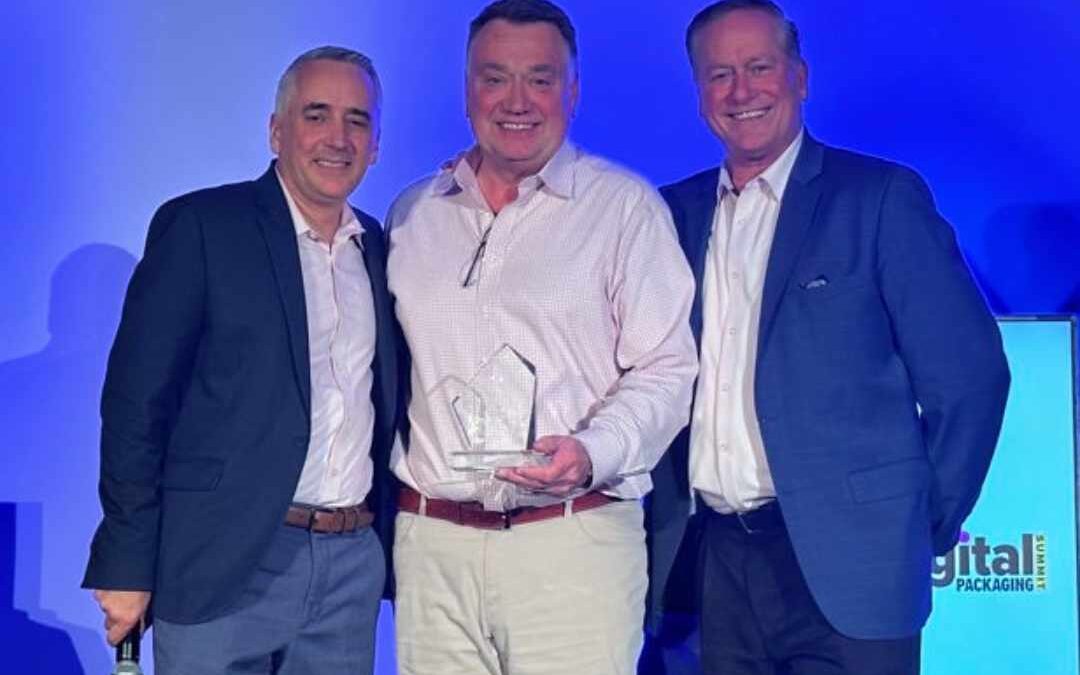 Ken Brown, Bobst Product Business Development Manager (center), receives the award from Event Director David Pesko (left) and Chris Lyons (right).